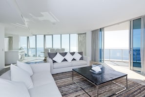 Una sala de estar moderna con un sofá, una mesa de centro y vista al océano.