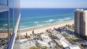 A high-rise hotel with a view of the beach and ocean.