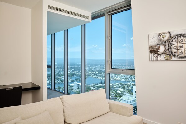 A modern living room with a large window offering a city view.