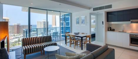A modern apartment with a balcony, a dining area, and a kitchenette.