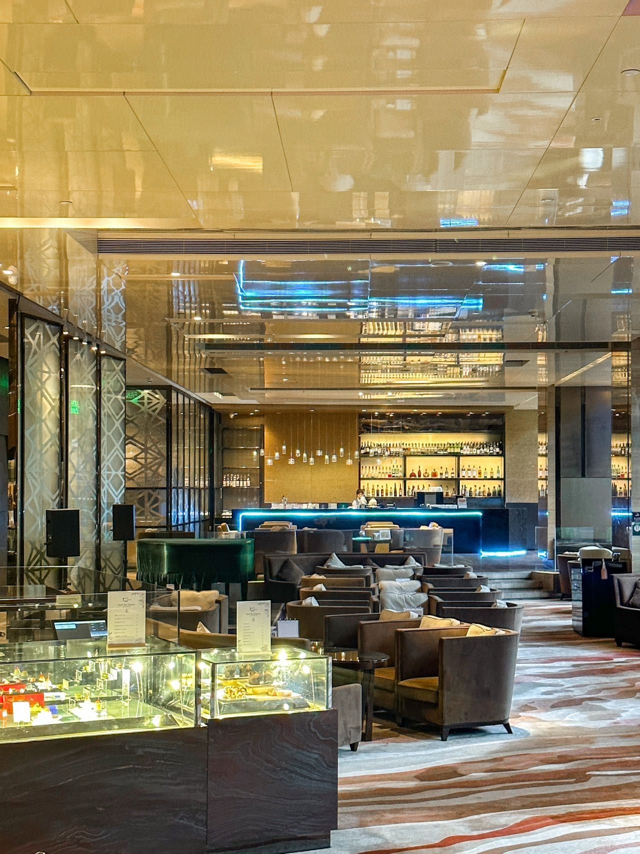 A modern bar area with seating and a display case.