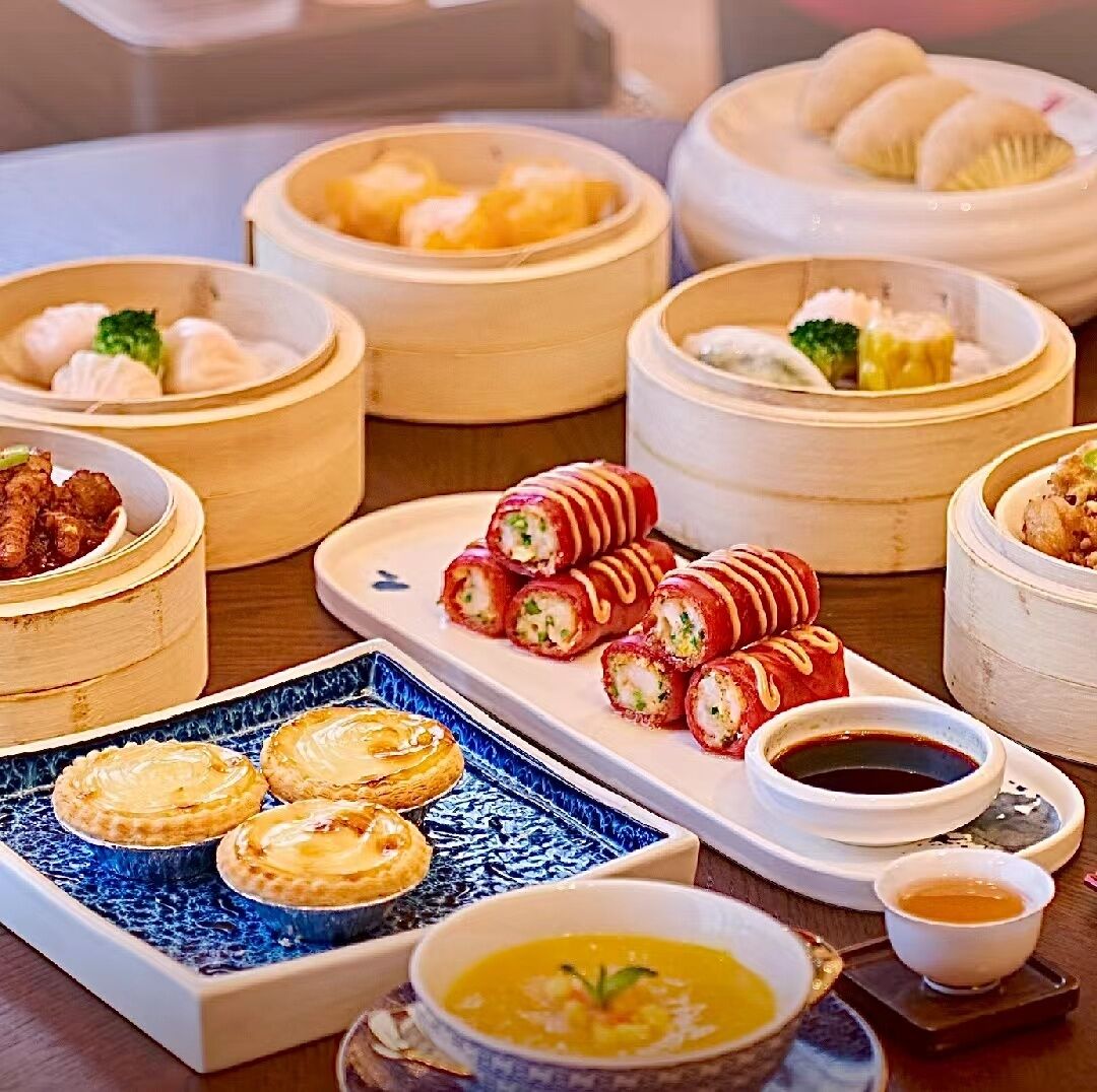A variety of food items including dumplings, sushi, and pastries, suggesting a dining setting.