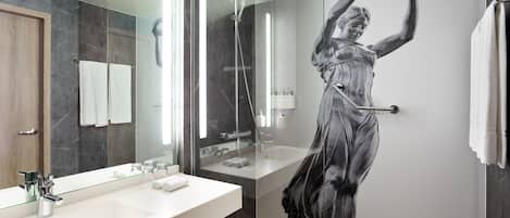 Un baño moderno con un espejo grande, una ducha y una pared de mármol.