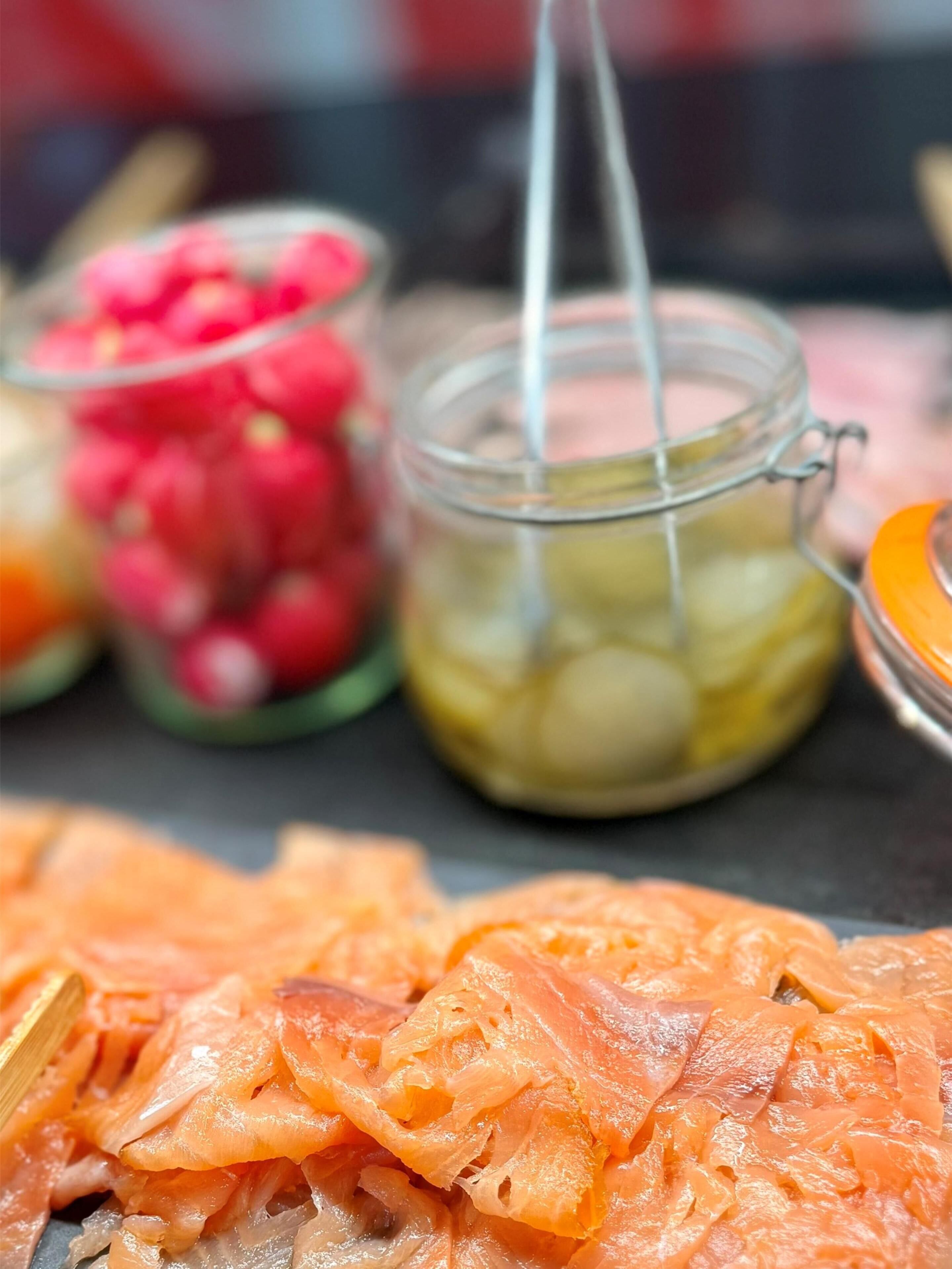 Primer plano de alimentos, incluyendo salmón y verduras encurtidas.