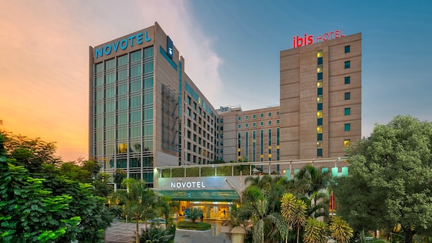 A Novotel hotel with a modern design, featuring a prominent glass facade and a rooftop garden. - Ibis Bengaluru Outer Ring Road (Bengaluru)