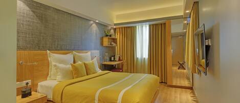 A modern hotel room with a wooden bed, bedside tables, a TV, and a large window with curtains.
