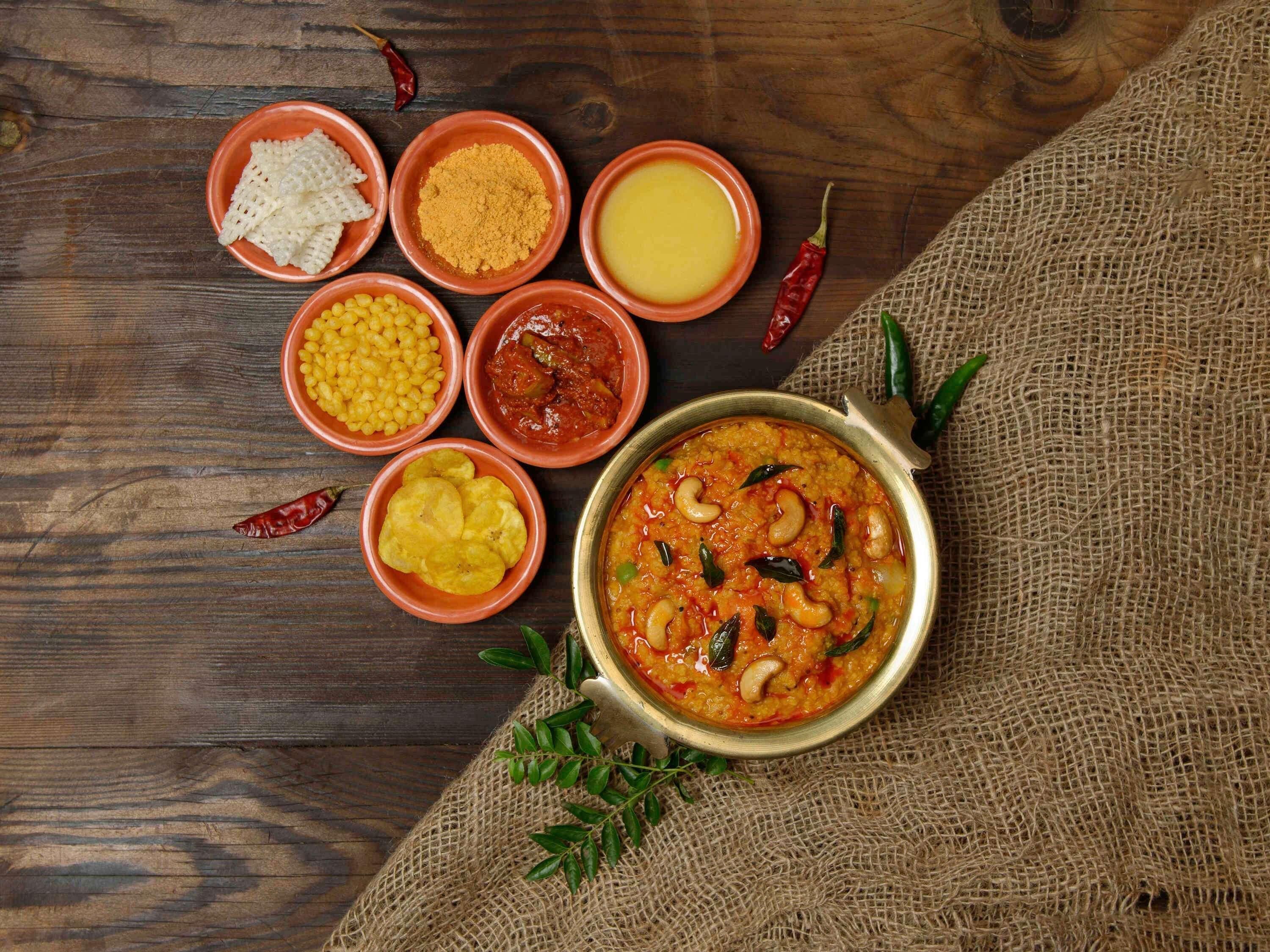 A variety of Indian dishes and spices on a wooden table.