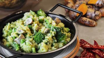 A pan of mixed vegetables with a handle, surrounded by whole spices.