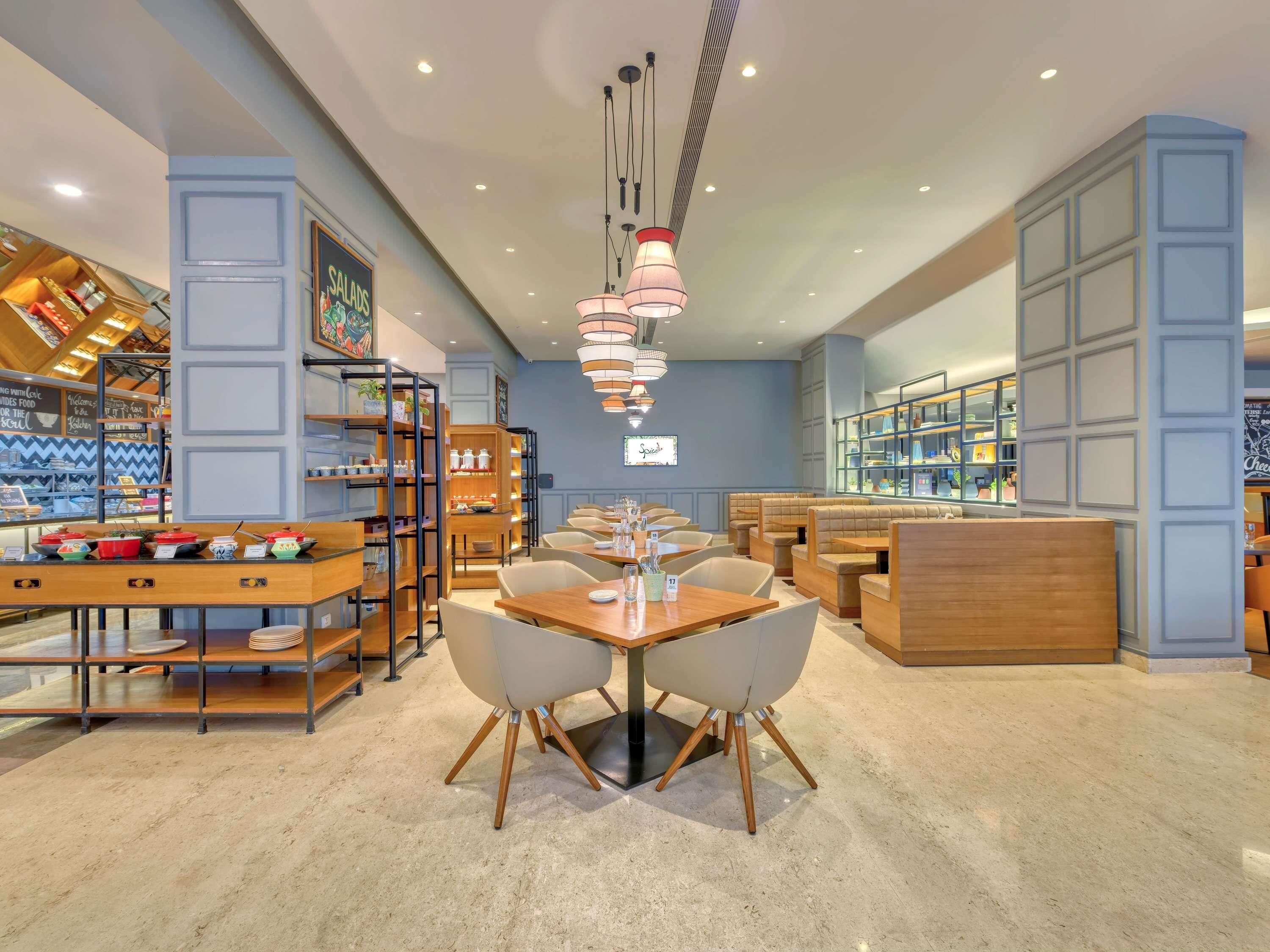 A restaurant interior with a central dining table, booths, and a counter.