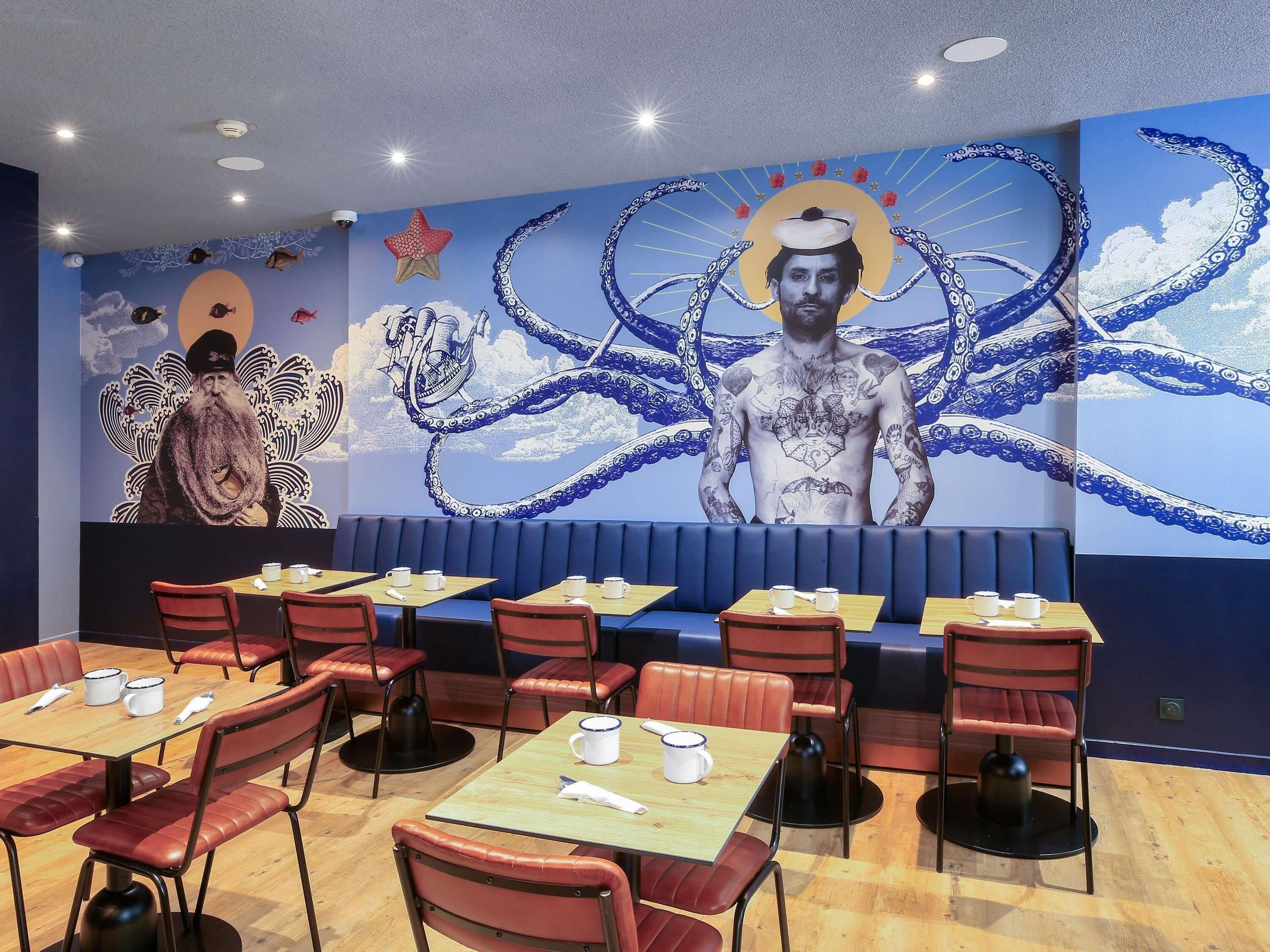 Un restaurante con cabinas, mesas y un gran mural en la pared.