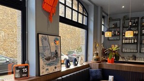 A modern bar with a seating area, large windows, and a view of the street. - ibis Styles Saint-Malo Centre Historique (Saint-Malo)