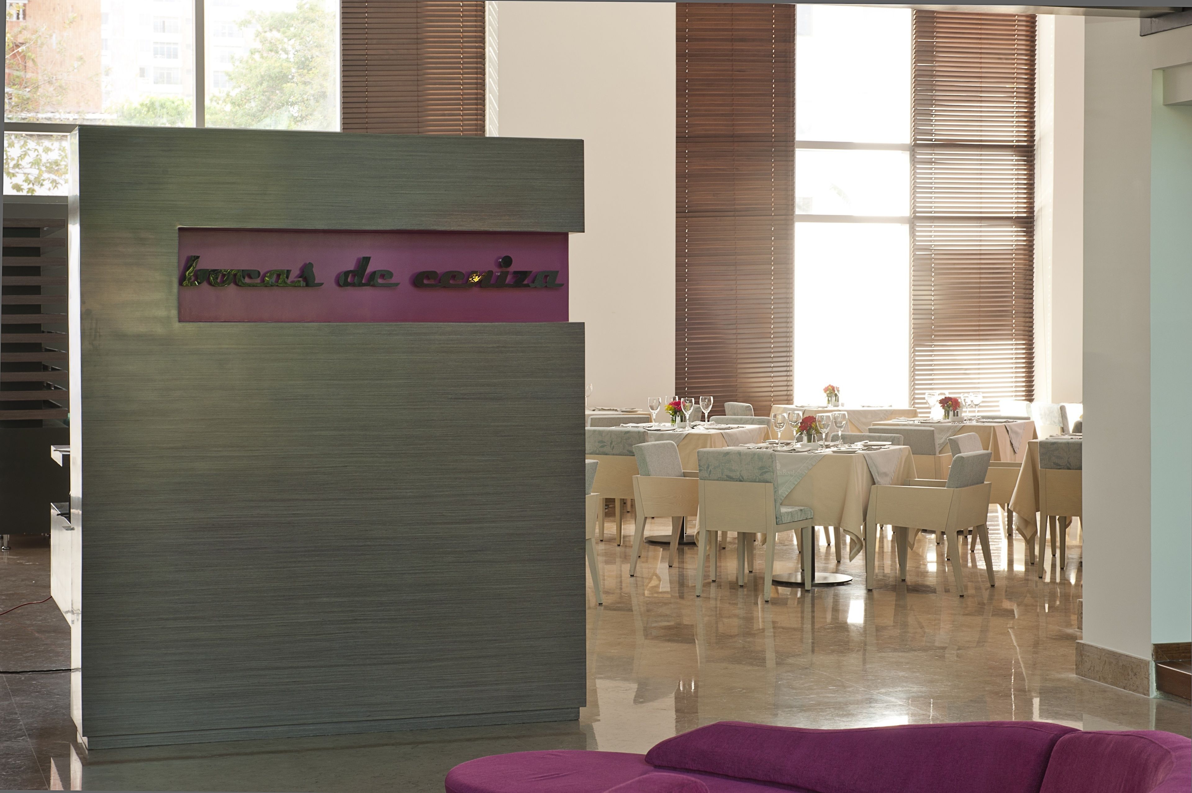 Un restaurante con un letrero que dice "bocas de costa" y un interior moderno con mesas y sillas.