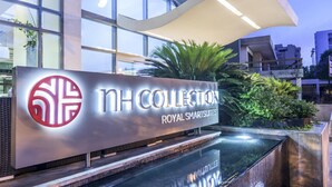 A modern building with a sign reading "NH COLLECTION Royal SmartSuites" and a water feature in front. - NH Collection Barranquilla Smartsuites Royal (Barranquilla)