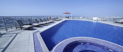 Piscine extérieure, parasols de plage, chaises longues