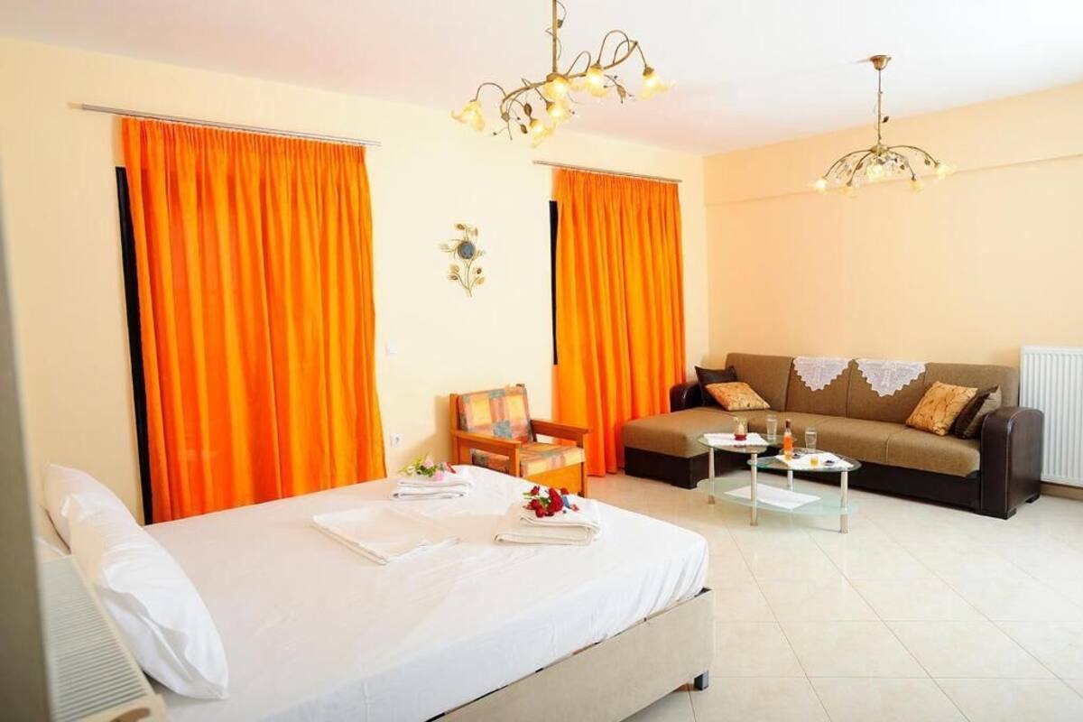 A hotel room with a bed, a sofa, a coffee table, and a chair.
