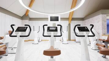 A fitness center with elliptical machines, a central monitor, and a ceiling light fixture.