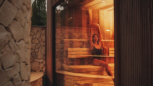 A sauna with wooden benches and stone walls. - Aspria Royal La Rasante (Brussels)