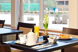 Enjoy a peaceful breakfast with a view from the comfort of your room, where a beautifully set table awaits with a teapot, fresh flowers, and a selection of pastries.
