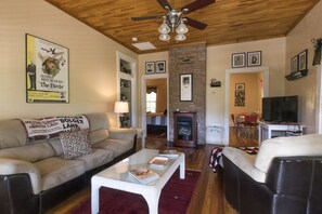 Movie Galley Suite, 1 King Bed and 1 Queen Sofa Bed, Patio | Living area | 32-inch flat-screen TV with satellite channels, TV, fireplace - Calhoun House Inn & Suites (Bryson City)