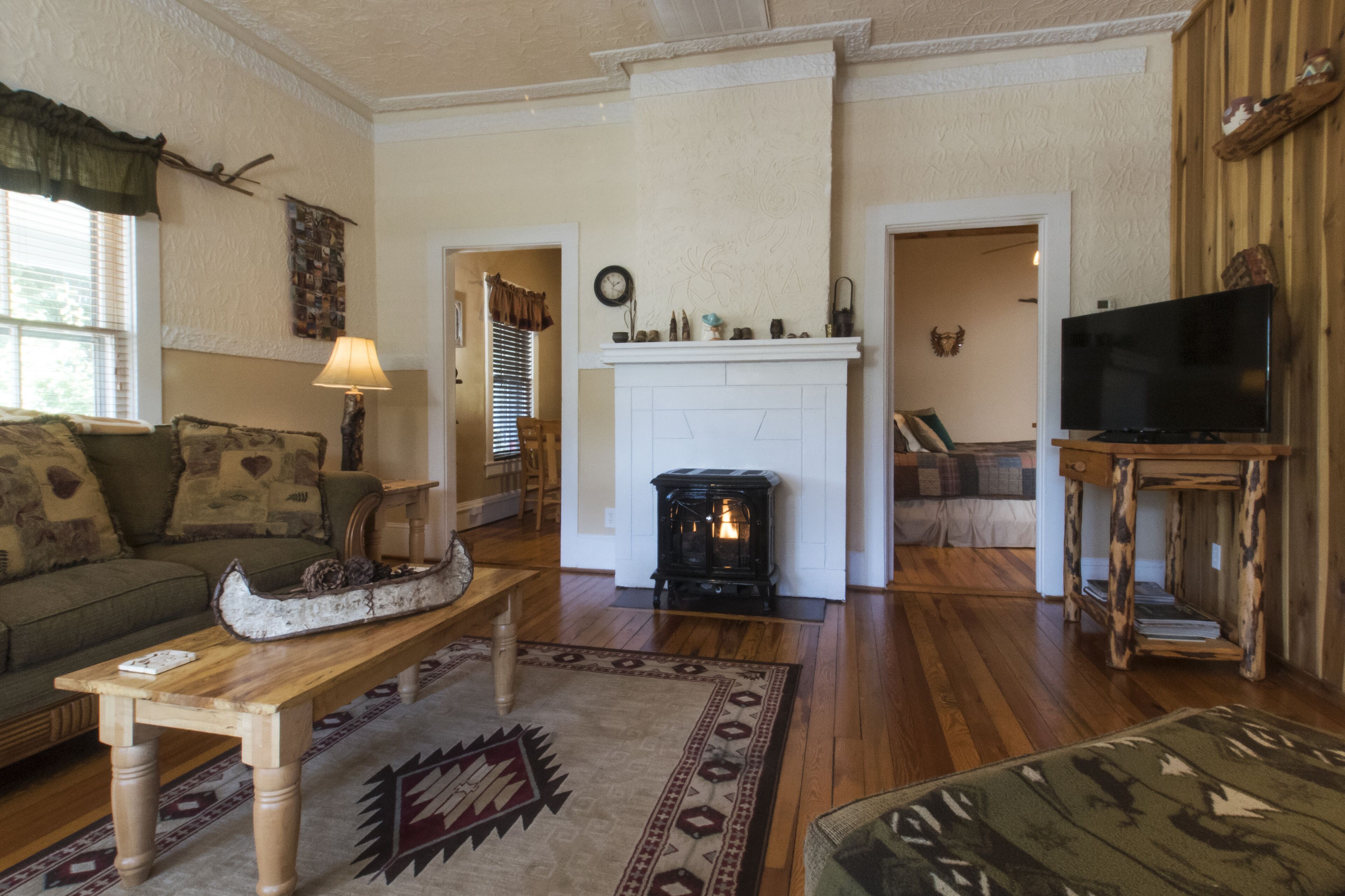 Uma sala de estar acolhedora com lareira, televisão e sofá.