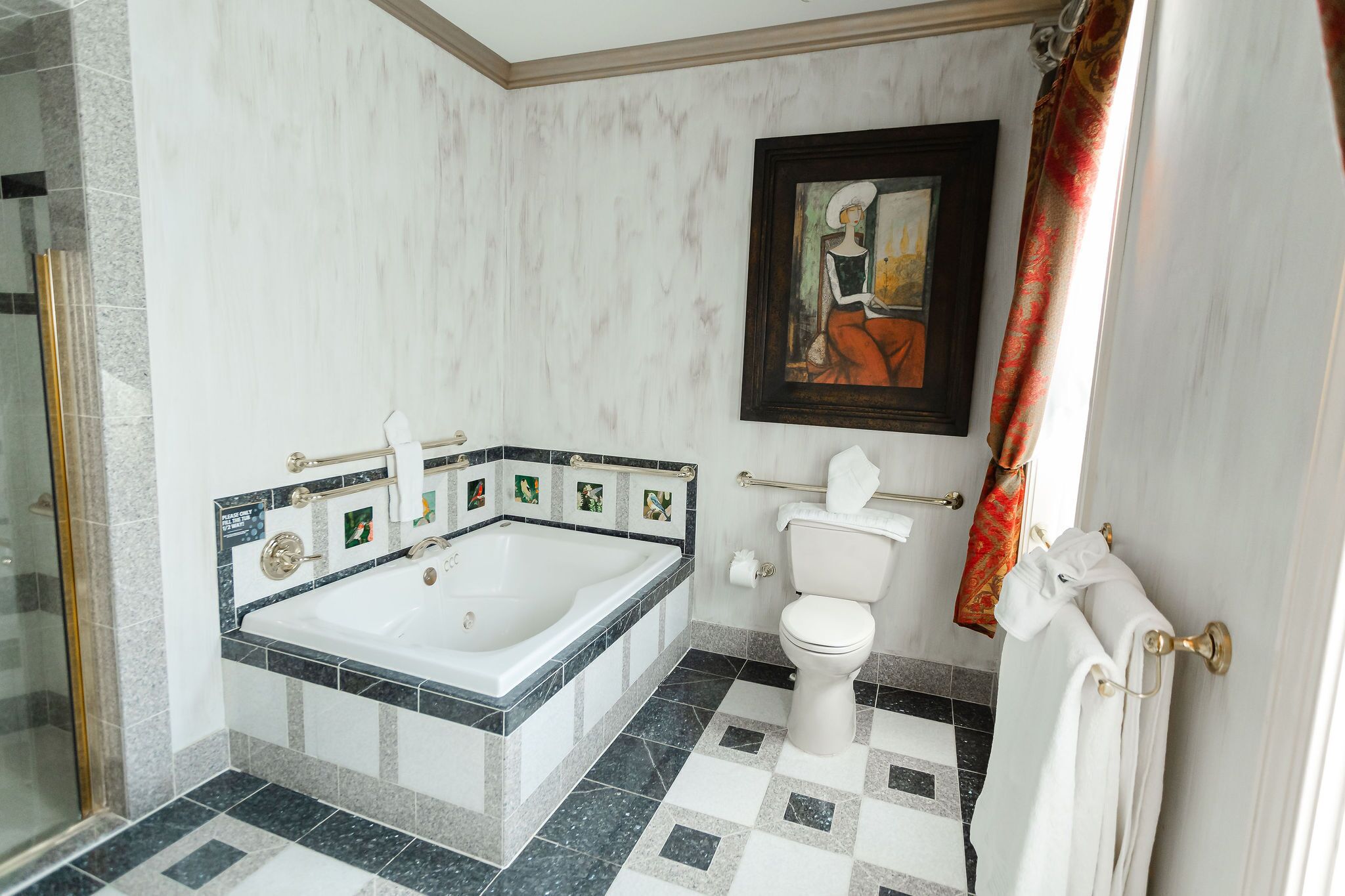 Ein Badezimmer mit Badewanne, Toilette und Duschbereich.