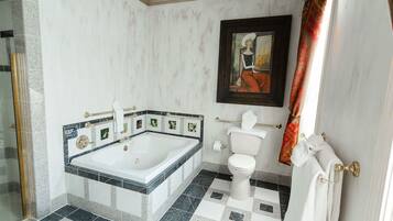 Ein Badezimmer mit Badewanne, Toilette und Duschbereich.