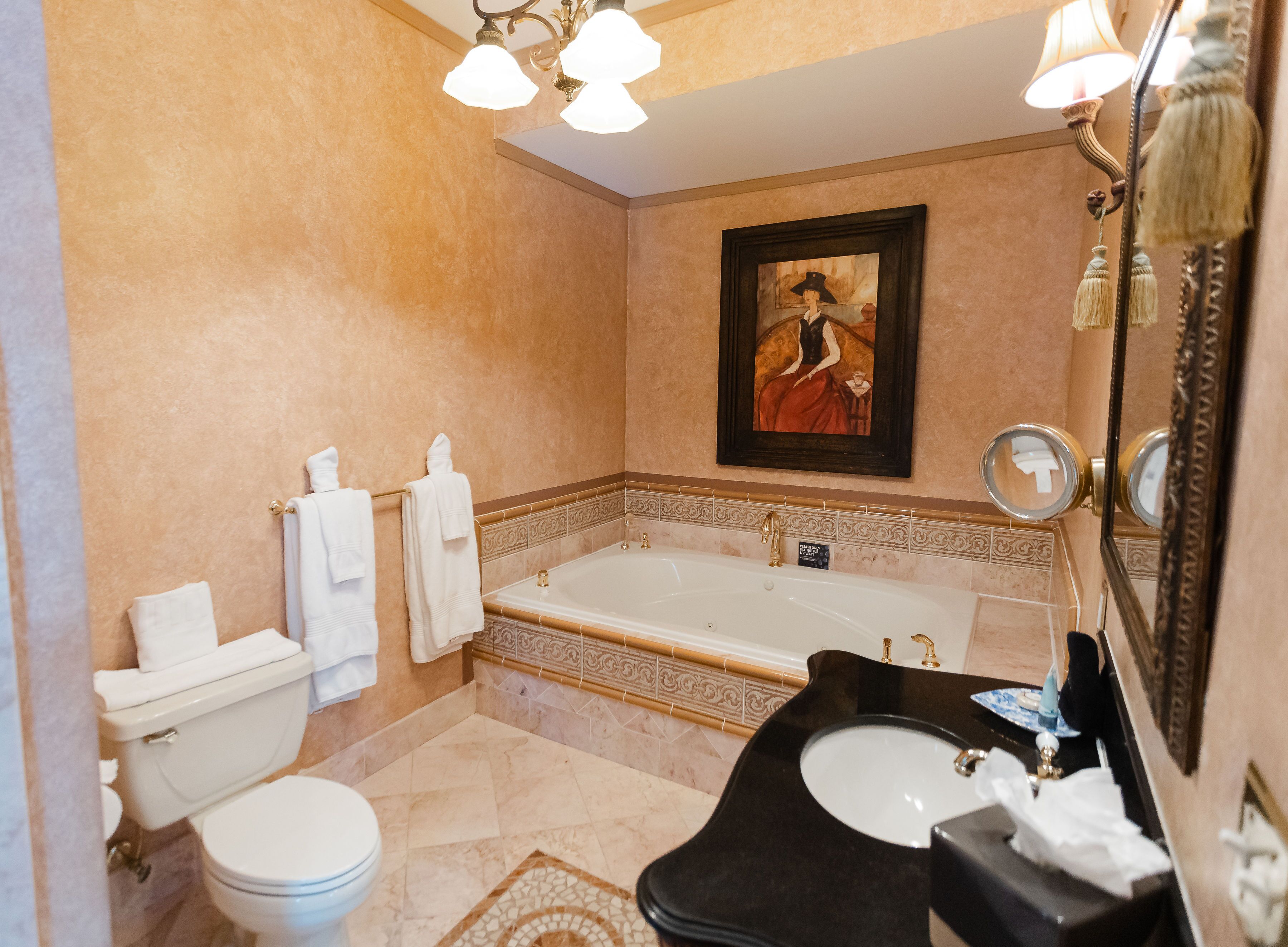 Un baño con bañera, dos lavamanos, inodoro y espejo.