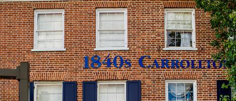 A brick building with a sign reading "1840s Carrollton Inn."