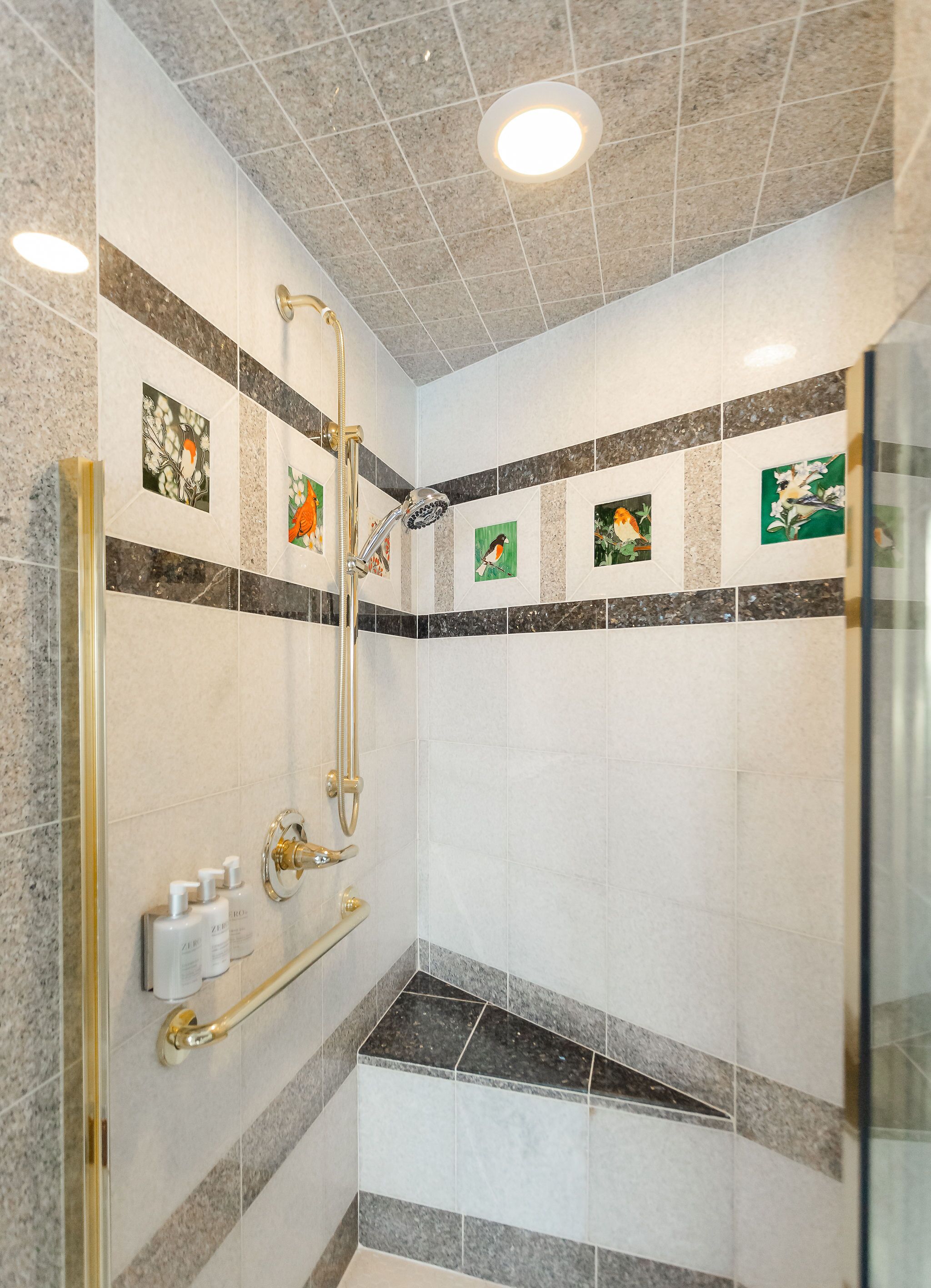 A modern shower area with a glass door, a handheld showerhead, and a handheld shower attachment.