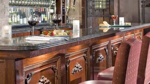 A bar area with a wine rack, bar counter, and seating. - Red Coach Inn (Niagara Falls)