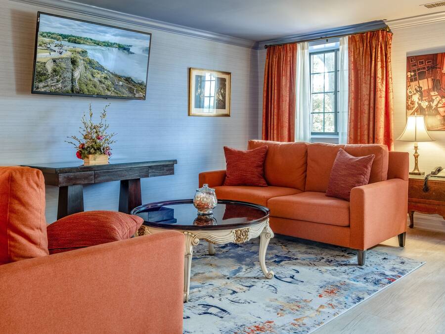A living room with a sofa, a coffee table, and a TV mounted on the wall.