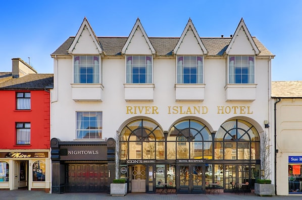 Un hotel de estilo arquitectónico clásico, con un letrero destacado que dice 'River Island Hotel'.