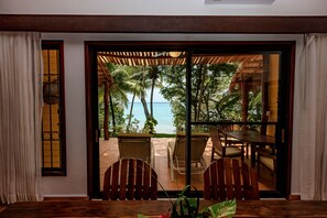 A room with a view of the sea, a wooden table, and two chairs. - Hotel Rancho Encantado (Bacalar)