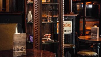 A bar area with wooden furniture, a sign reading 'NEVERNESS for sure,' and a vintage-style cabinet with glass doors.