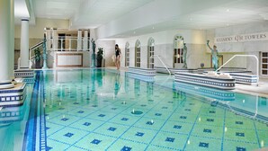 Una piscina interior con suelo de baldosas y un puesto de salvavidas.