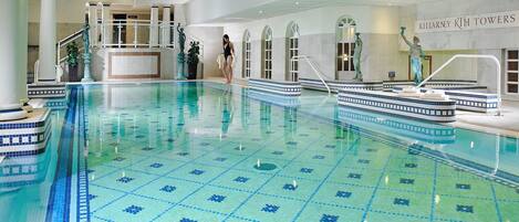 Una piscina interior con suelo de baldosas y un puesto de salvavidas.