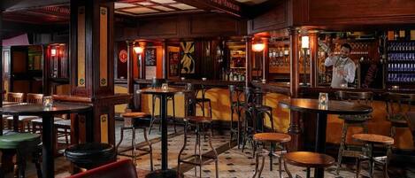 A bar area with wooden furniture, tables, and chairs.