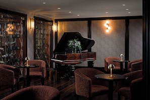 A room with a grand piano, plush seating, and a decorative wall. - Killarney Towers Hotel & Leisure Centre (Killarney)