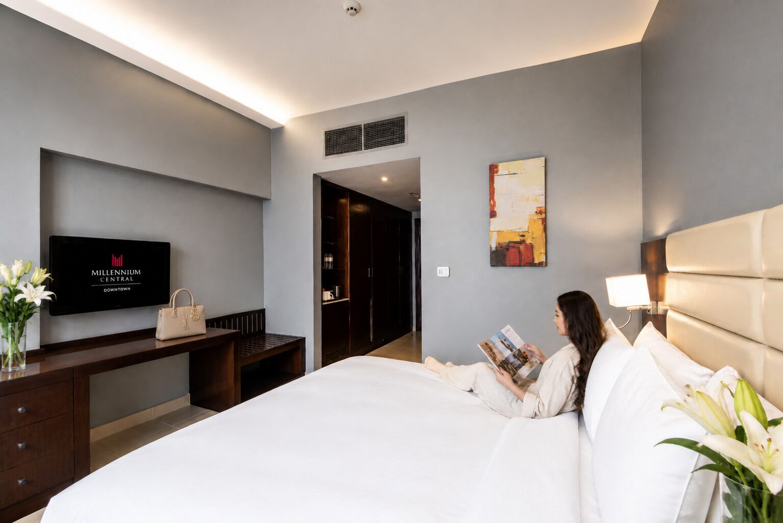 A hotel room with a bed, a TV, a desk, and a wardrobe.