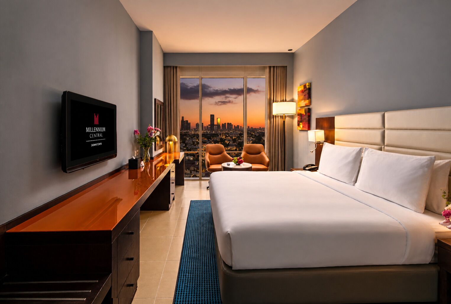 A hotel room with a bed, desk, TV, and a city view.
