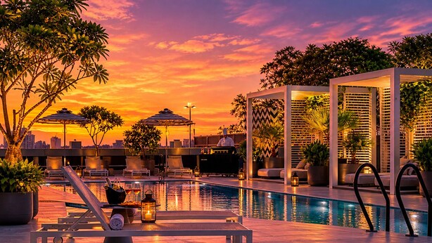 A rooftop pool area with lounge chairs, umbrellas, and a view of the sunset. - Millennium Central Dubai Downtown (Dubai)