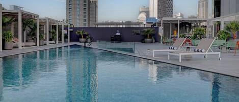 Una piscina al aire libre, sillones reclinables de piscina