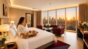 A hotel room with a large bed, a city view, a dining table, and a sofa. - Millennium Central Dubai Downtown (Dubai)