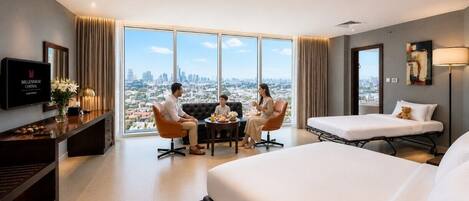 A hotel room with a large bed, a sofa, a TV, and a city view.