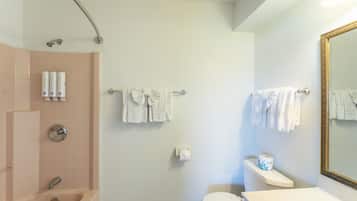 A bathroom with a bathtub, toilet, sink, and a mirror.