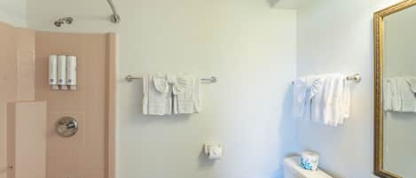 A bathroom with a bathtub, toilet, sink, and a mirror.
