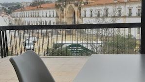 A view from a balcony with a table and chairs, overlooking a historic building with ornate architecture. - Hotel Santa Maria (Alcobaça)