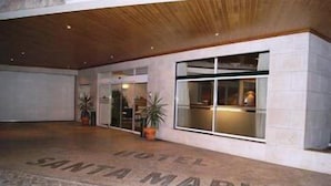 A hotel entrance with a tiled floor, potted plants, and a large window. - Hotel Santa Maria (Alcobaça)