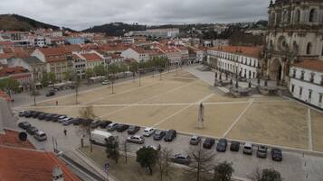 A plaza with a large open space, surrounded by buildings with red-tiled roofs.