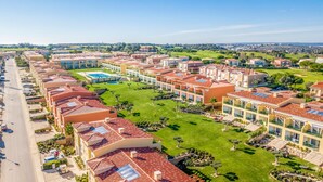 Een resort met meerdere gebouwen, een zwembad en verzorgde gazons.